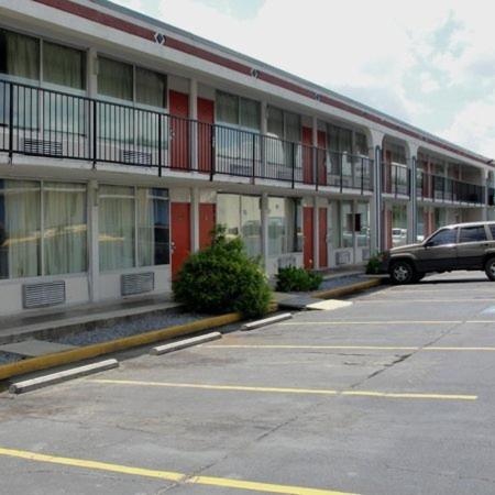 a building with a car parked in a parking lot at Royal Inn in Alcoa