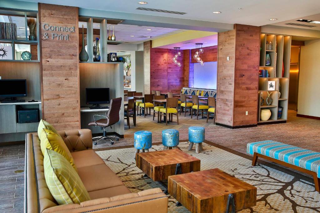 a lobby with a couch and tables and a dining room at Fairfield Inn & Suites by Marriott Savannah Midtown in Savannah