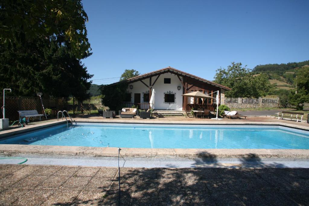 una piscina frente a una casa en Chalet con piscina en Peón "Los Tres Robles", 