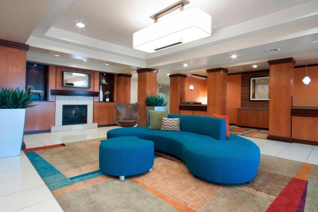 a living room with a blue couch and a fireplace at Fairfield Inn & Suites El Centro in El Centro
