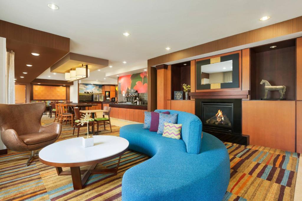 a living room with a blue couch and a fireplace at Fairfield Inn & Suites Omaha East/Council Bluffs, IA in Council Bluffs