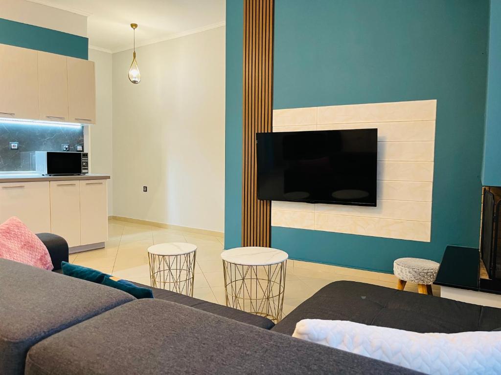 uma sala de estar com um sofá e uma televisão de ecrã plano em eliTe deluxe residence em Kavala