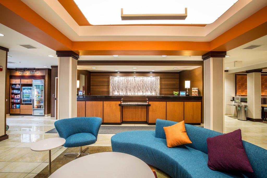a lobby with a blue couch and a bar at Fairfield Inn and Suites by Marriott Portsmouth Exeter in Exeter