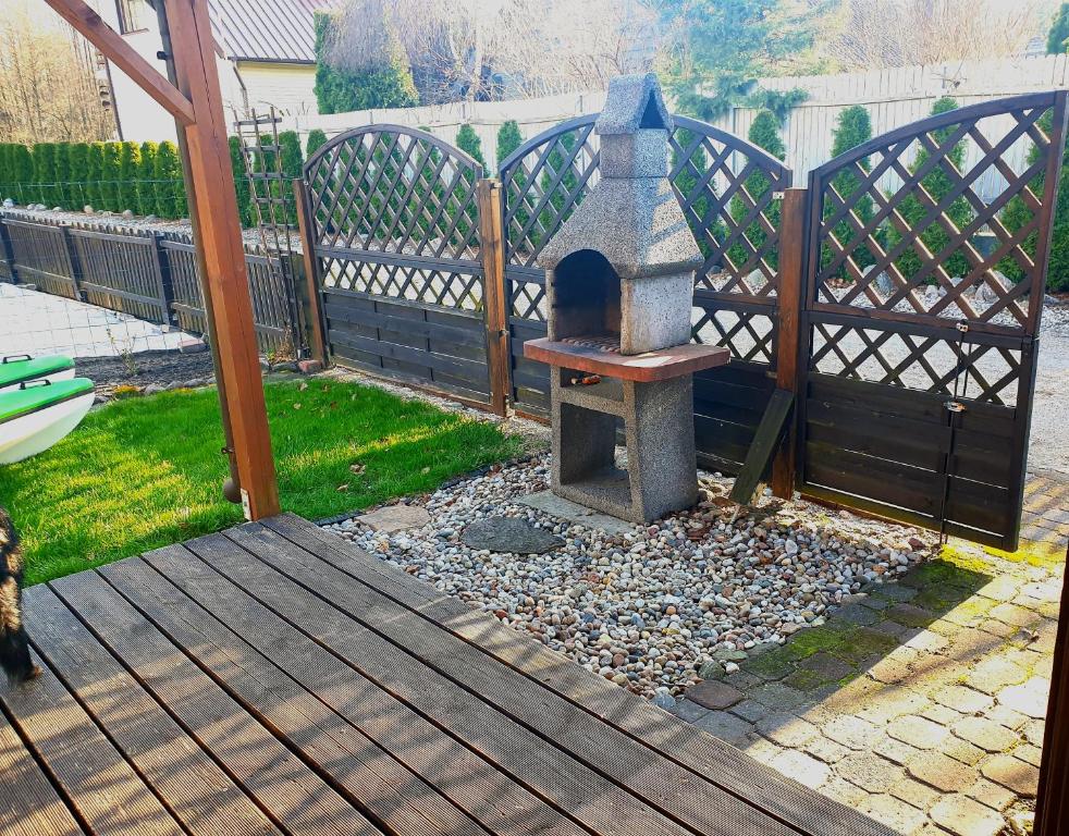 a outdoor grill in a yard with a wooden deck at Domki na Chabrowej in Augustów
