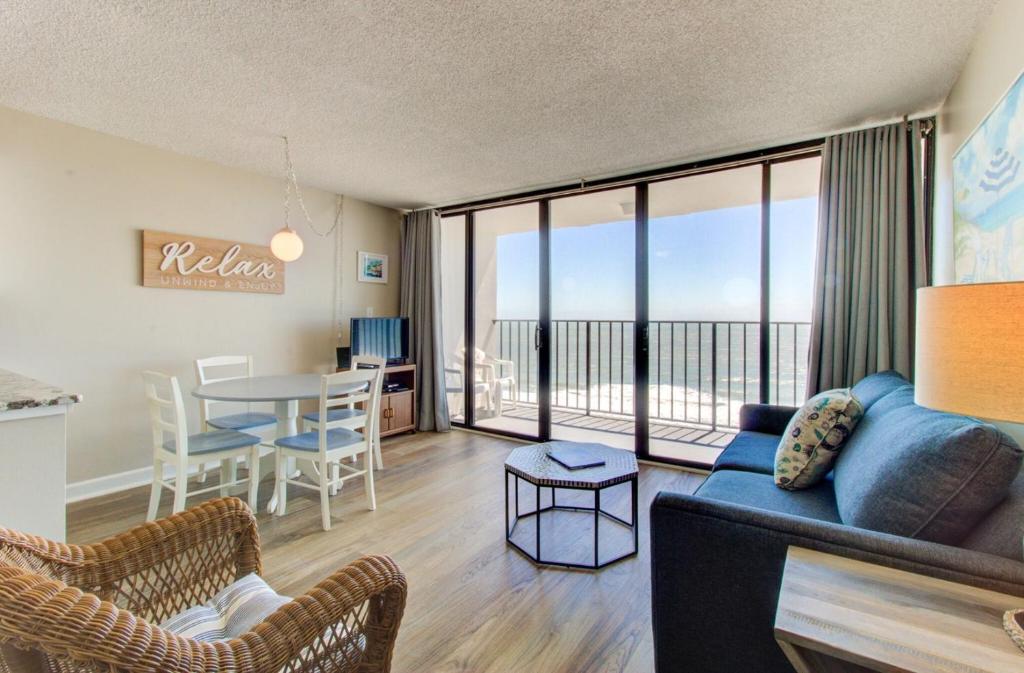カロライナビーチにある1010 Relax, Unwind, Enjoy by Atlantic Towersのリビングルーム(ソファ、テーブル、椅子付)