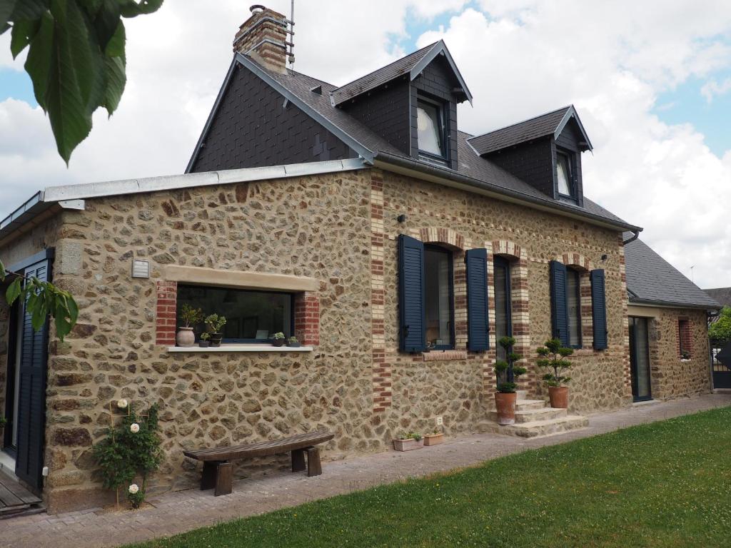 a stone house with a bench in front of it at Entre en Baie ! in Pontaubault