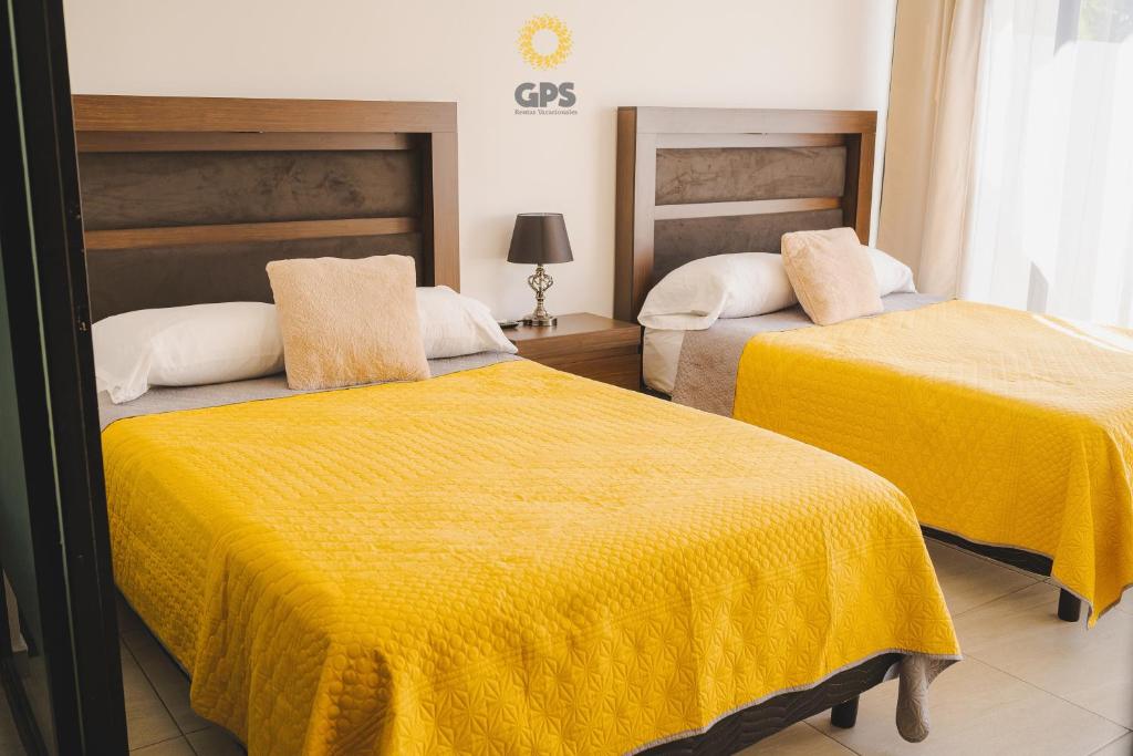 a bedroom with two beds with yellow sheets at Hotel boutique 402 in Mazatlán
