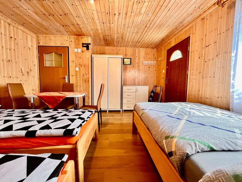a bedroom with two beds and a table in it at Pokoje Nad Klifem in Trzęsacz