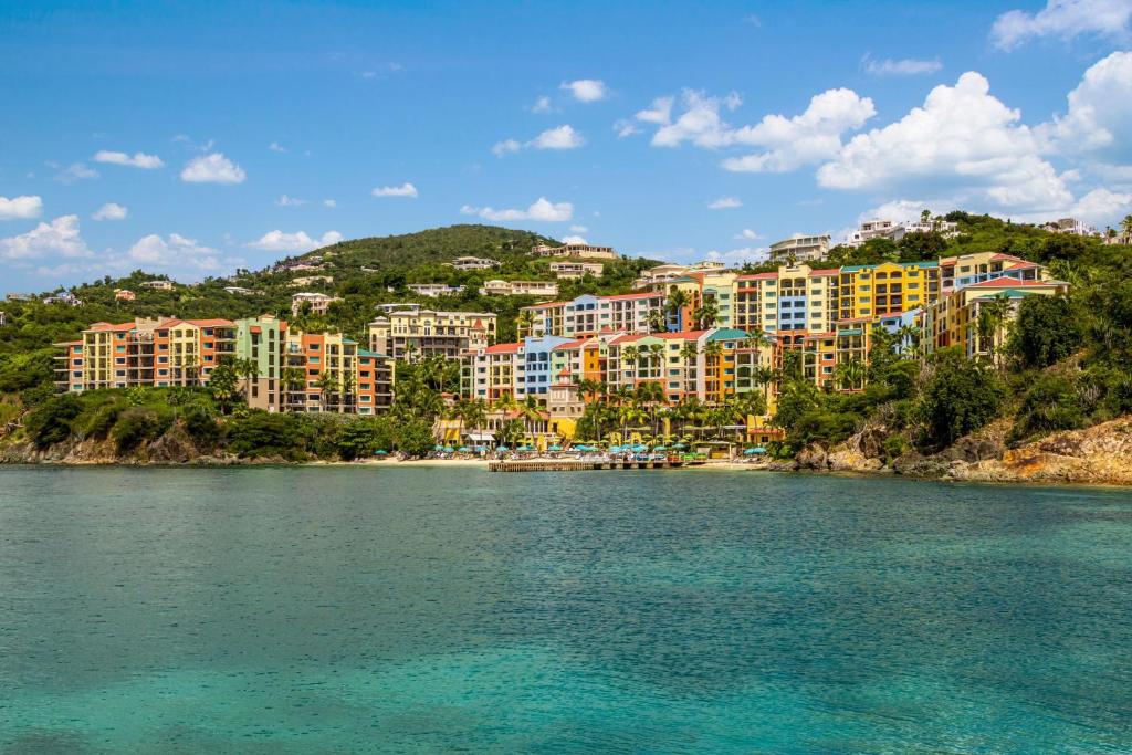 eine Gruppe von Gebäuden auf einem Hügel neben einem Wasserkörper in der Unterkunft Marriott's Frenchman's Cove in Estate Thomas