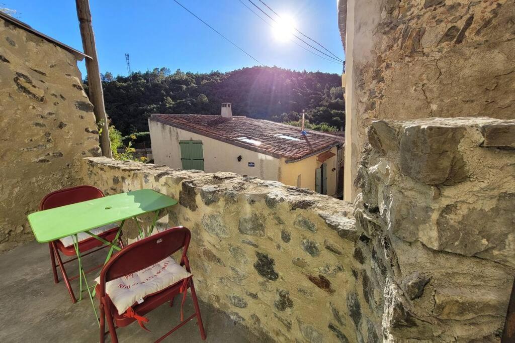 two chairs and a table on a stone wall at Le Cantou de Juliette (studio) in Prugnanes