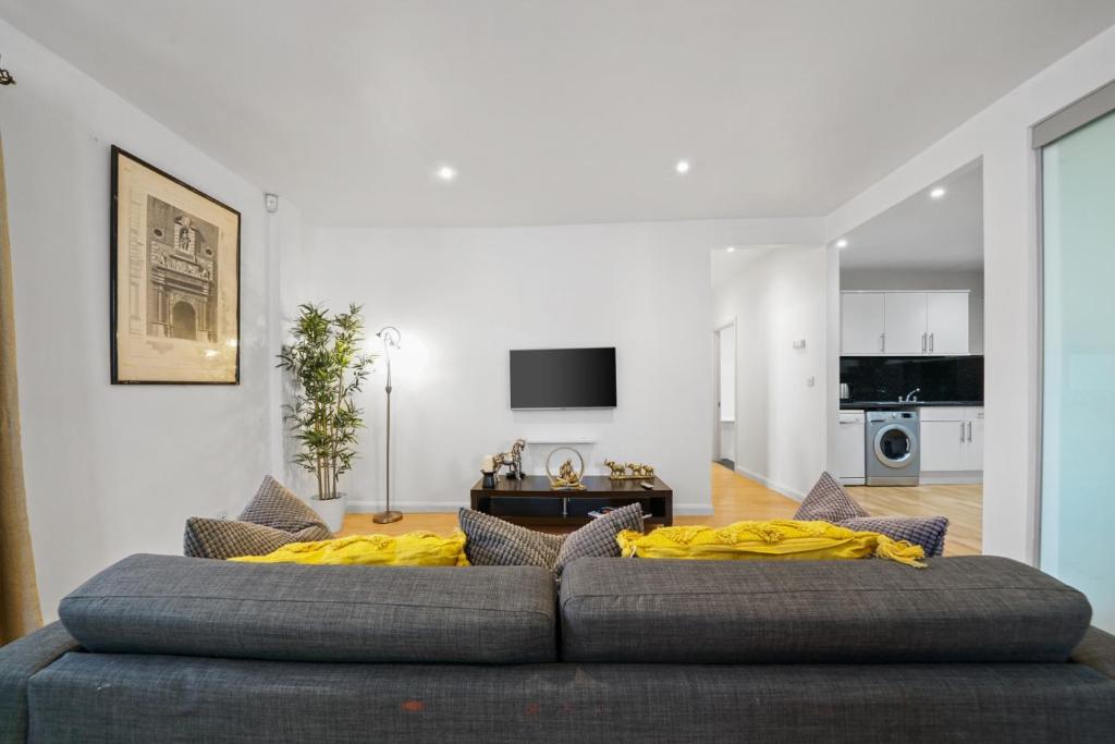 ein Wohnzimmer mit einem Sofa und gelben Kissen in der Unterkunft Modern 2Bed Apartment London Cutty Sark O2 Arena Greenwich - Perfect for long stays in London