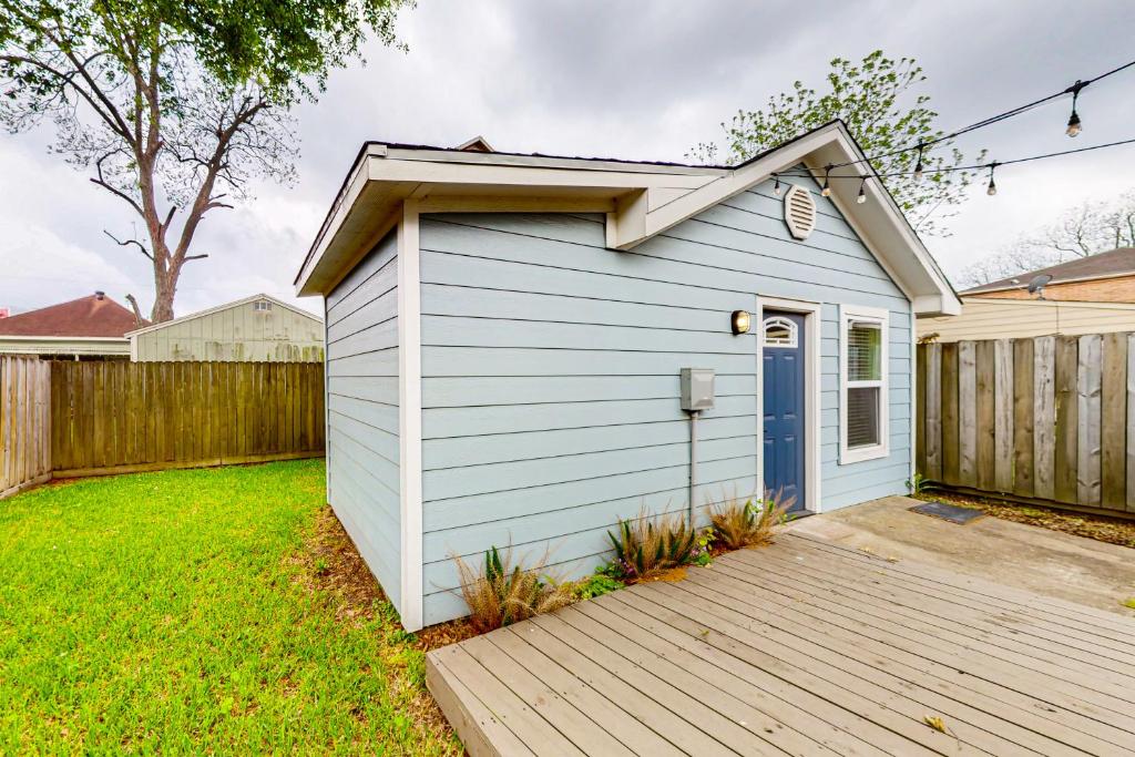 a small blue shed with a wooden deck at The Heights Garden Cottage in Houston