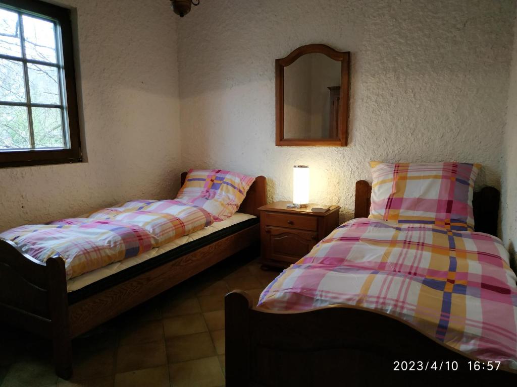 Duas camas individuais num quarto com um espelho. em Maison de vacances Diff em Puttelange-aux-Lacs