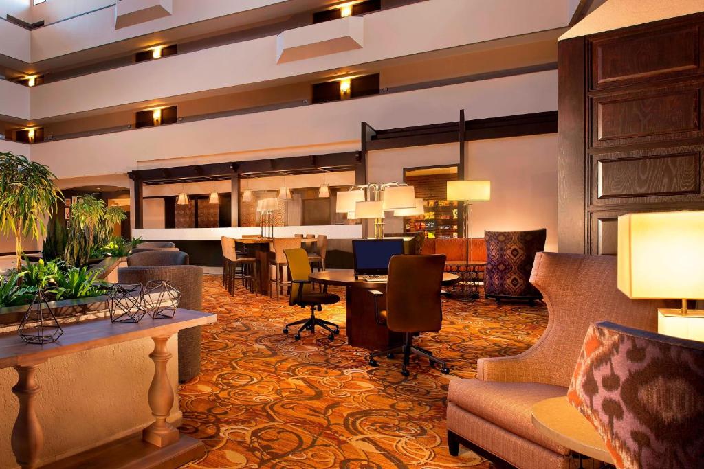 a hotel lobby with a desk and chairs at Sheraton Minneapolis West Hotel in Minnetonka