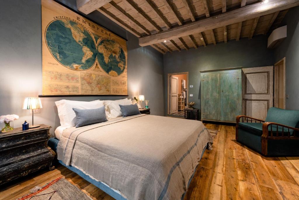 um quarto com uma cama grande e uma cadeira em Borgo Signature Rooms em Florença