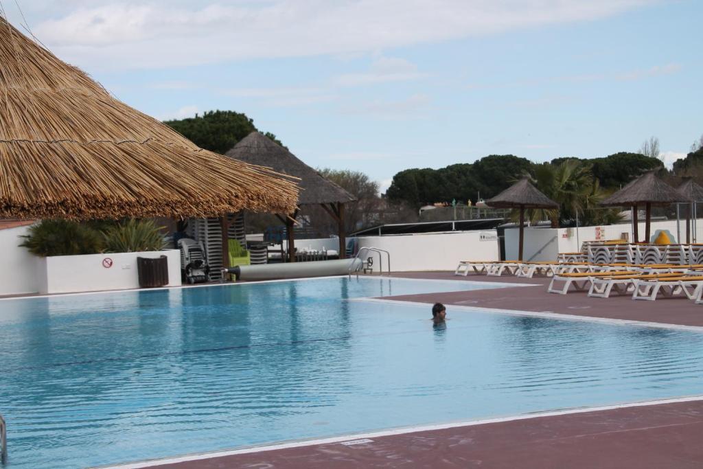 uma pessoa na piscina de um resort em mobil home au lac des rêves em Lattes