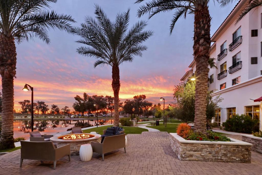a hotel patio with palm trees and a fire pit at Residence Inn by Marriott Phoenix Chandler/South in Chandler