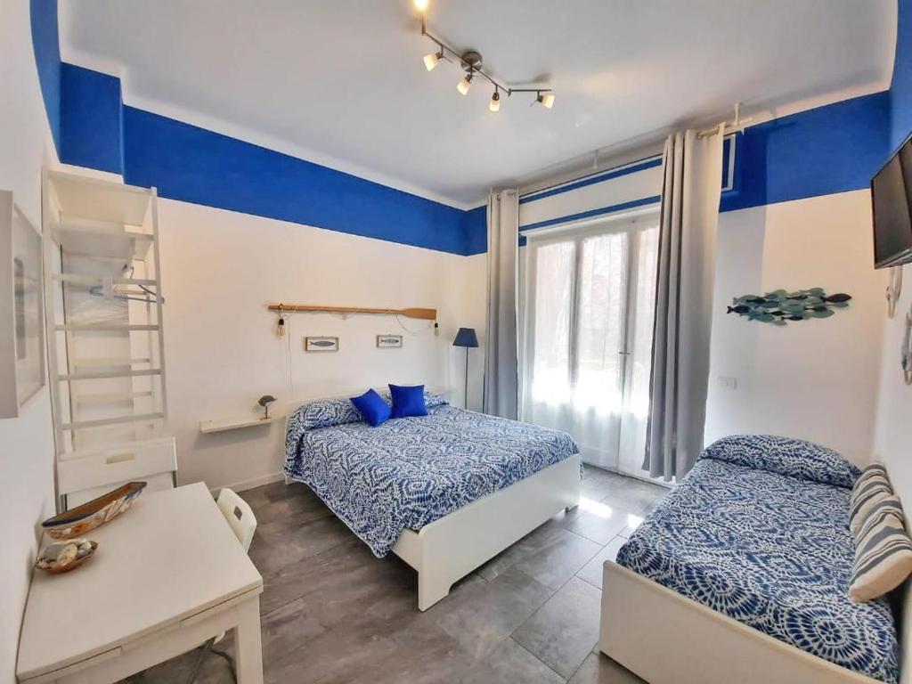 a bedroom with two beds and blue and white walls at Il Sogno Apartments in Monterosso al Mare