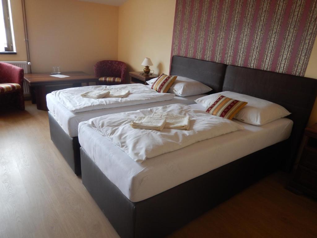 Dos camas en una habitación de hotel con toallas. en Konsky Dvor, en Brzotín