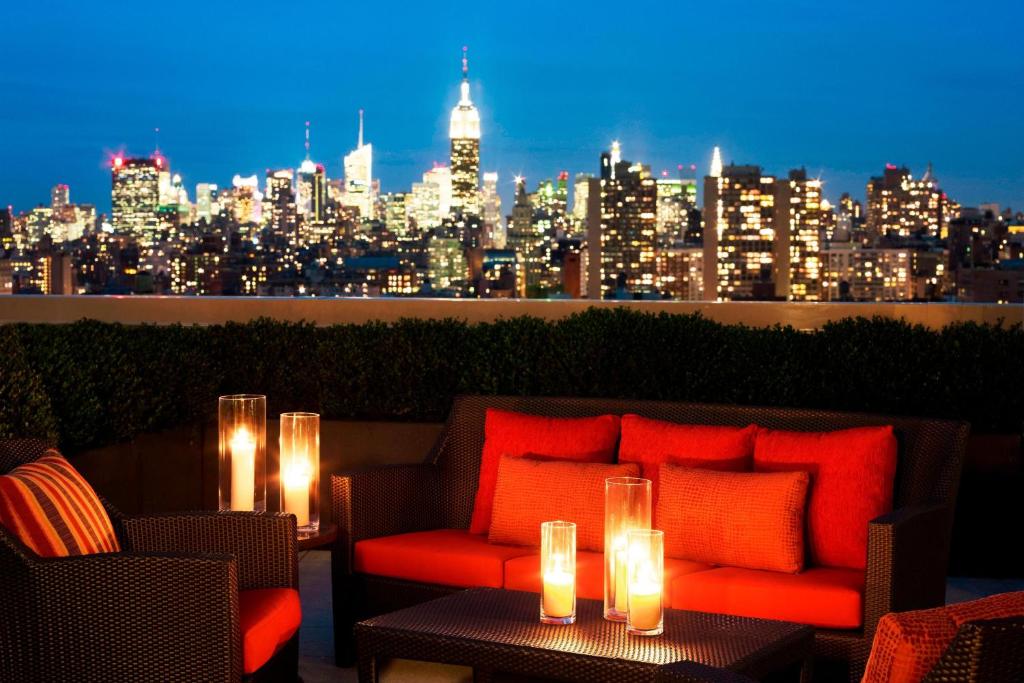 ein Sofa mit Kerzen auf einer Terrasse mit Skyline der Stadt in der Unterkunft Sheraton Tribeca New York Hotel in New York