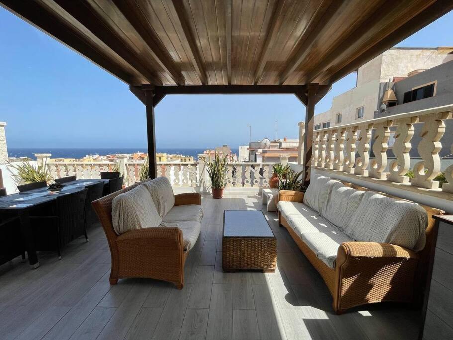 a patio with couches and chairs on a balcony at Casa Brisa del mar in La Jaca