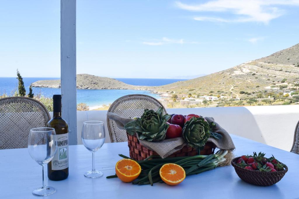 una cesta de frutas y verduras en una mesa con copas de vino en 'Paradise' says Cnn - 2 Bed Villa in Delfini Bay, en Delfini