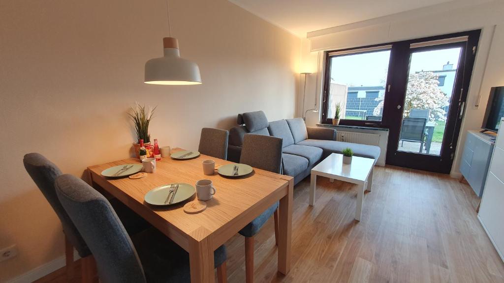 een woonkamer met een tafel en een bank bij Ferienwohnung Meerverliebt in Cuxhaven