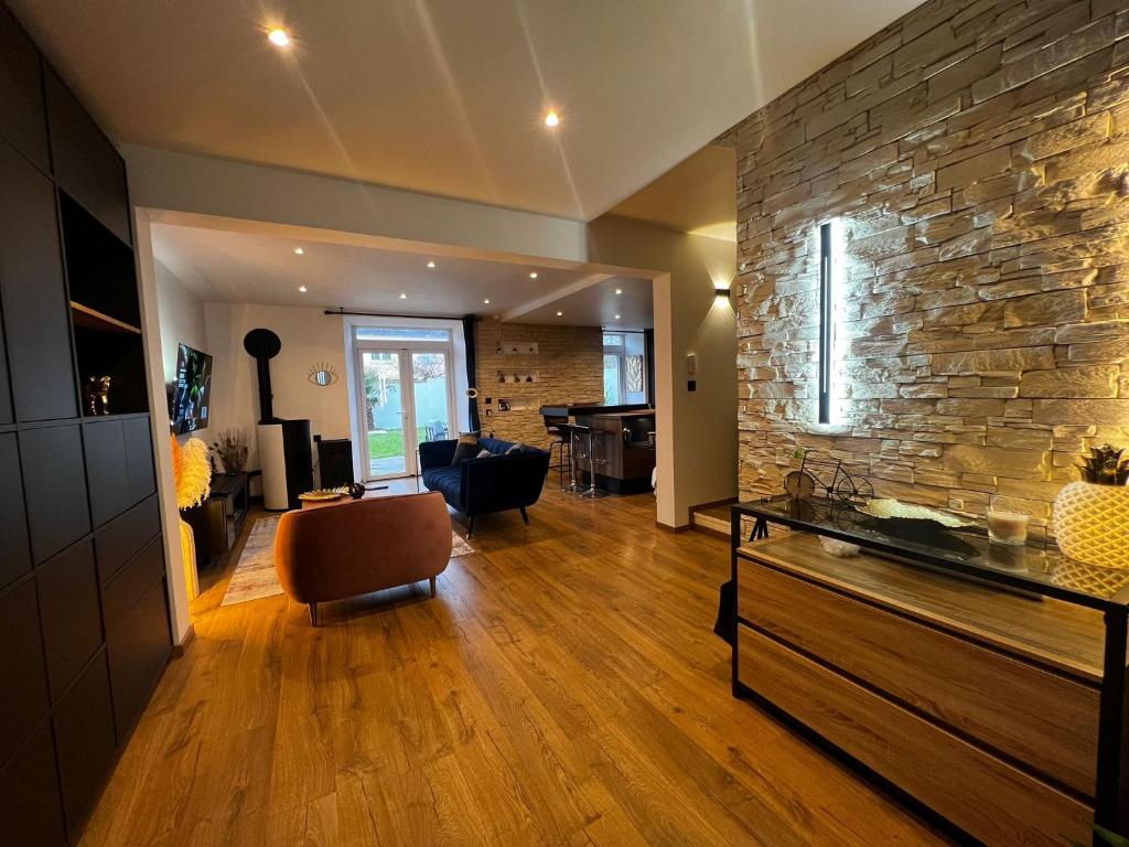 a living room with a stone wall and a fish tank at Maison Cocooning 3 chambres double in Douarnenez