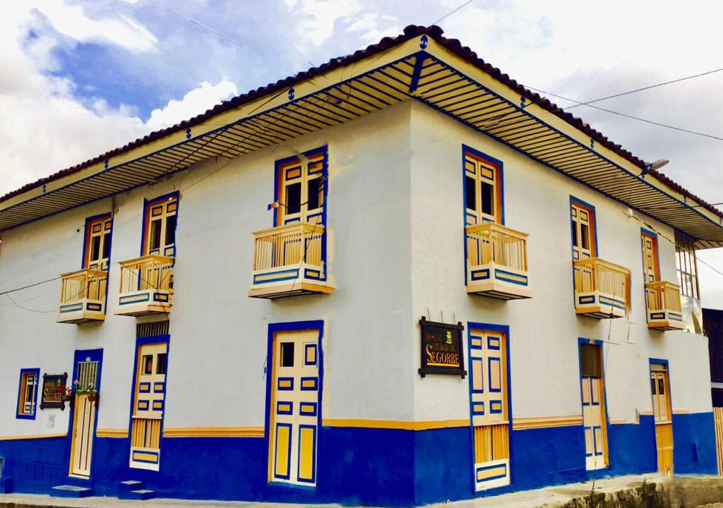Edificio blanco y azul con ventanas y balcones en Hostal Ciudad de Segorbe, en Salento