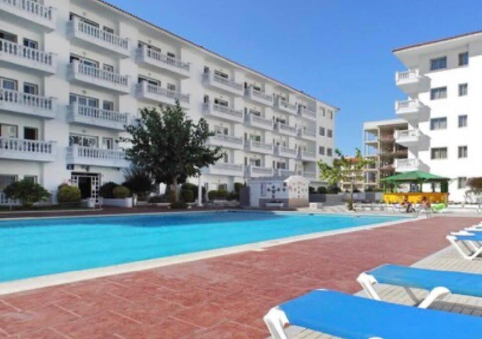 a swimming pool in front of a large building at Apartamento Europa con terraza in Blanes