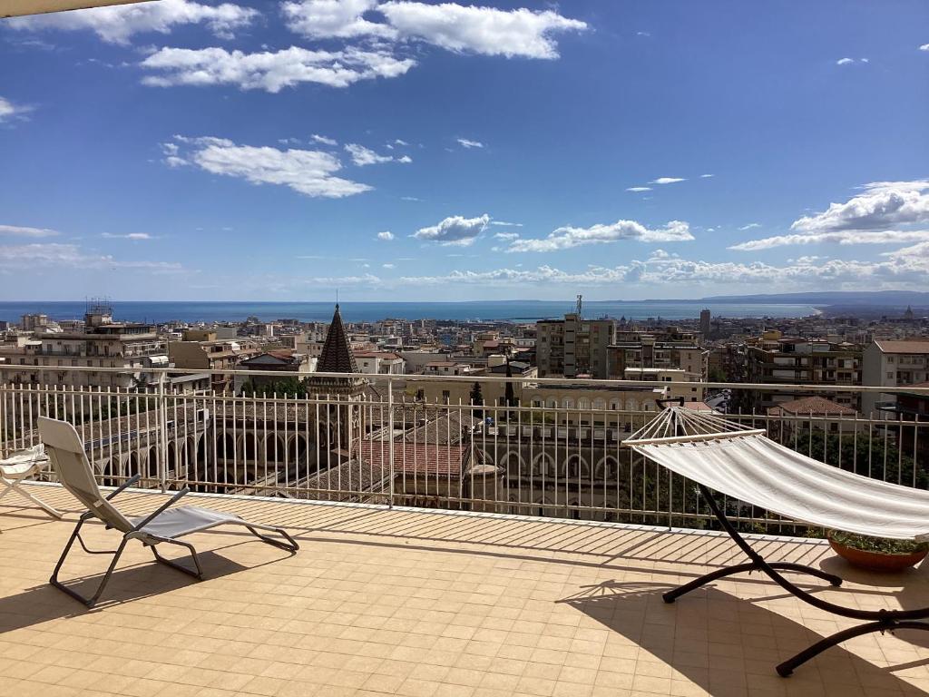 a balcony with a hammock and a view of a city at Top Floor Aparthotel Bentivoglio in Catania