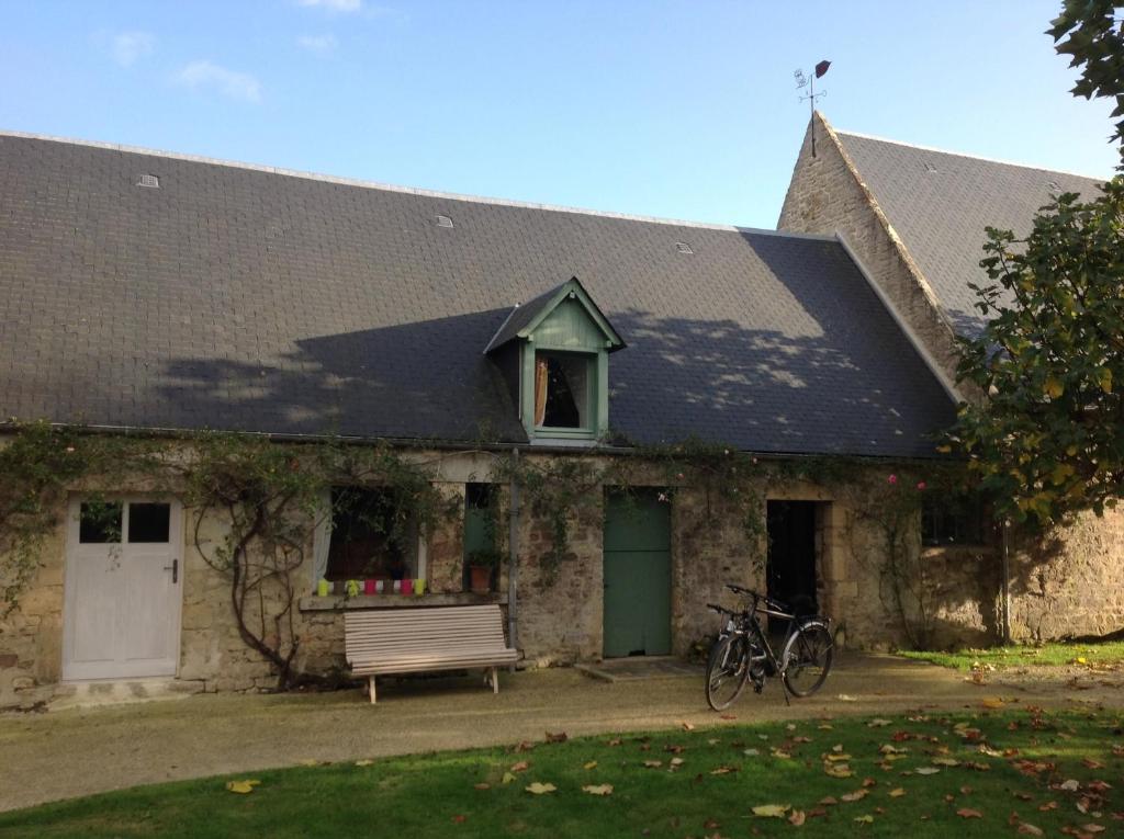 a building with a bench and bikes parked in front of it at Studio des Perriots in Englesqueville-la-Percée