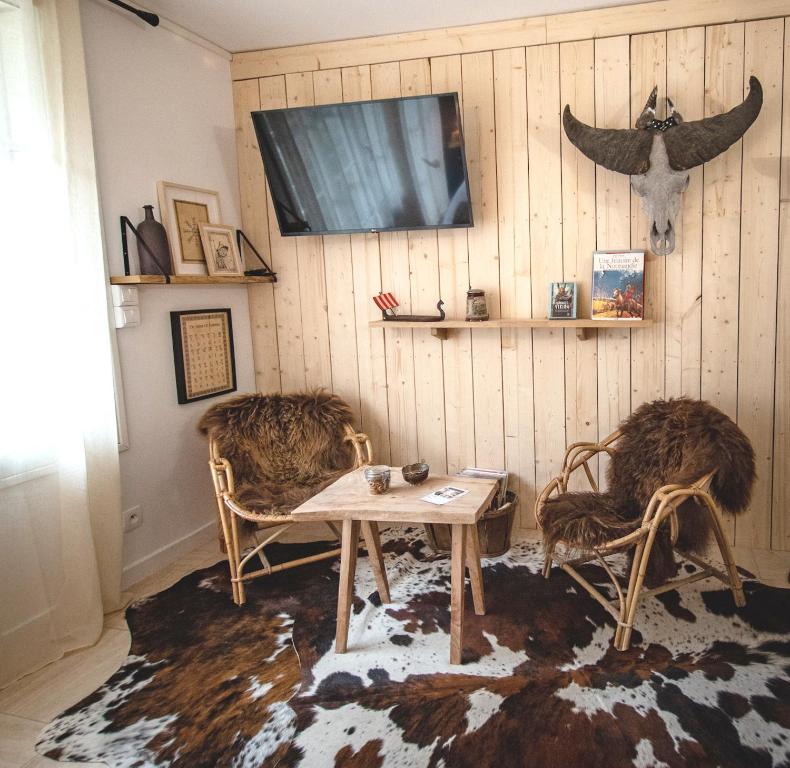 een woonkamer met 2 stoelen en een tafel bij Studio Insolite Viking in Caen