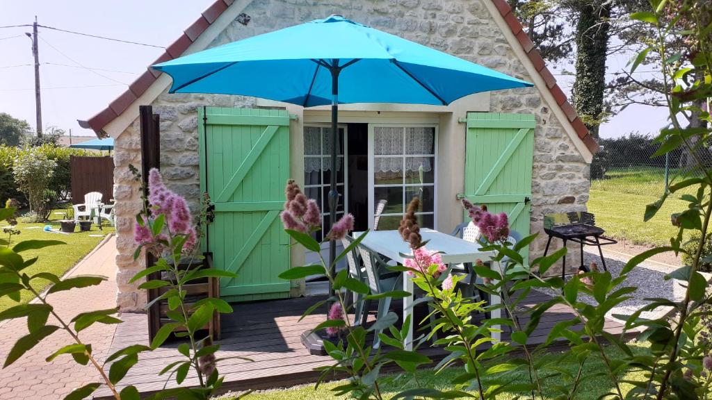 a cottage with a table and an umbrella at La Beuvrequentoise 2 in Beuvrequen