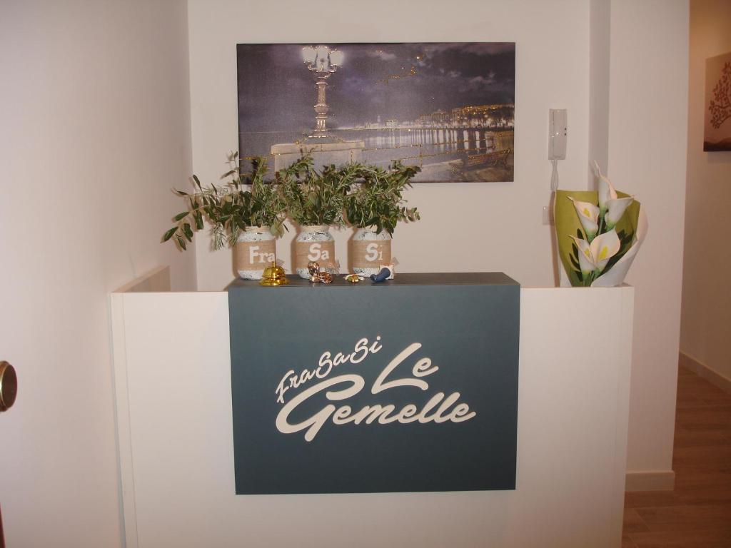 a sign on a counter with plants on it at Le Gemelle in Bari
