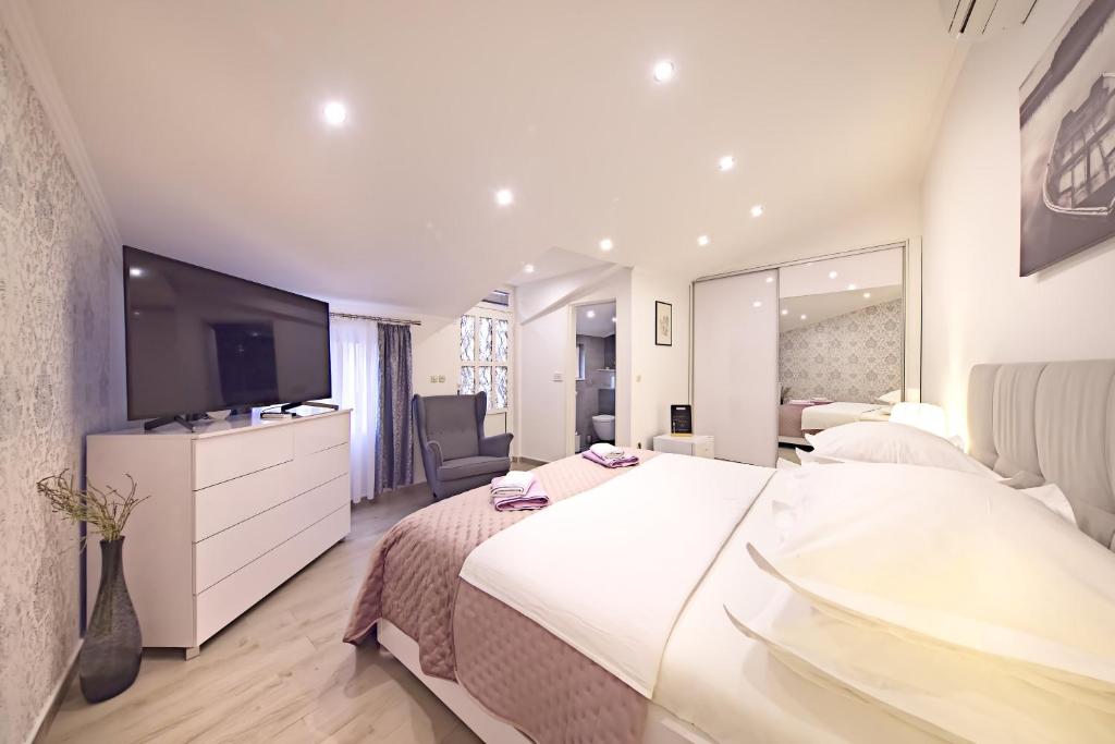 sypialnia z dużym białym łóżkiem i telewizorem w obiekcie Private room Niko w mieście Skradin