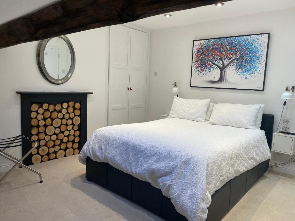 a bedroom with a bed and a tree painting on the wall at Dove House in Congleton