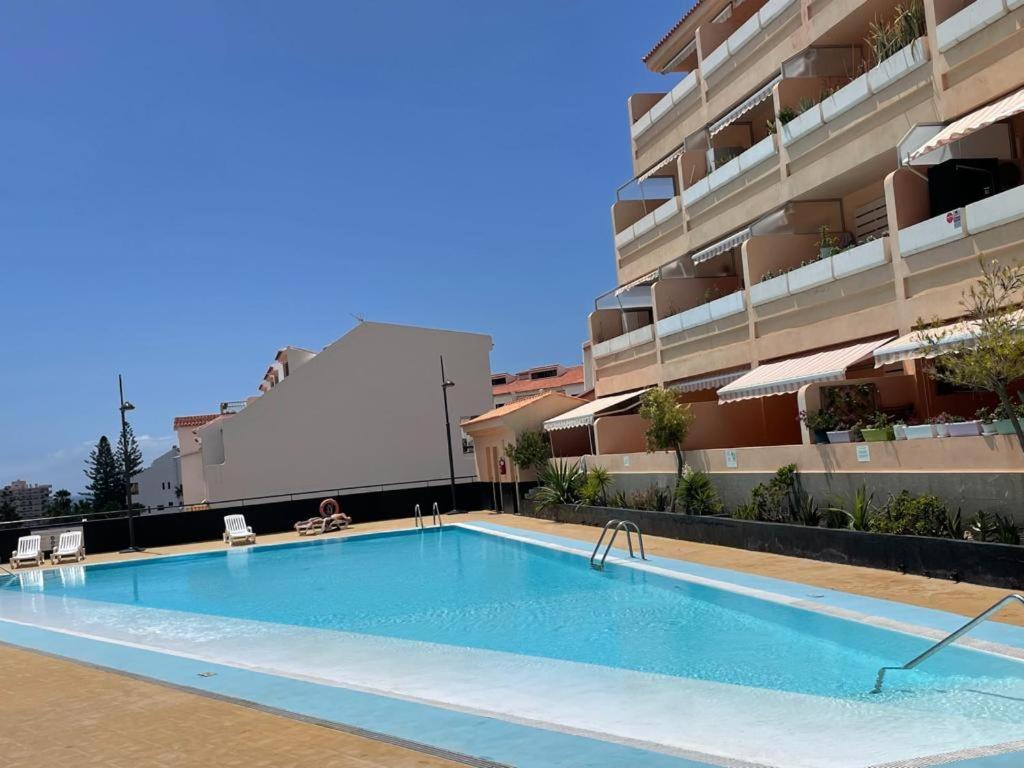 una piscina vacía frente a un edificio en Los Cristianos Apartamento en residencial Los Seres, en Los Cristianos