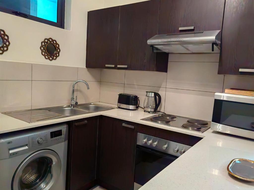 a kitchen with a sink and a washing machine at Classy and cosy Apt - Dainfern in Fourways