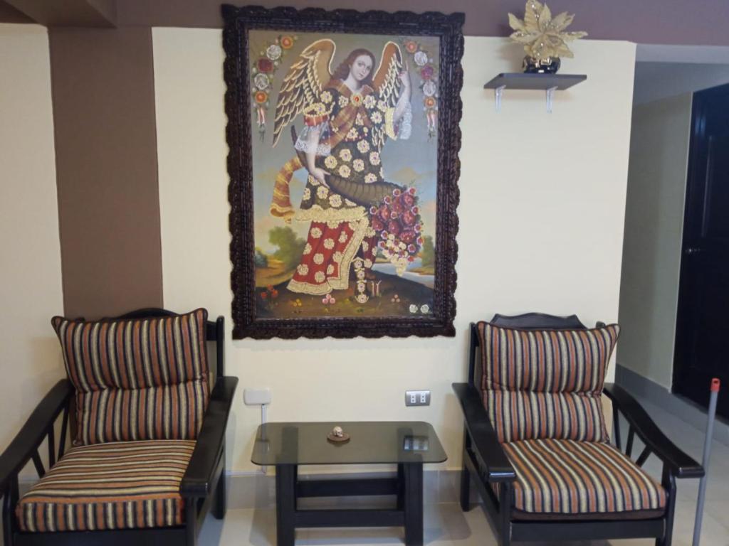 una habitación con 2 sillas y un cuadro en la pared en La Casita de Gabriel, en Cusco
