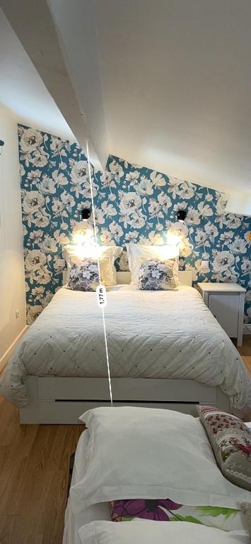 - une chambre avec 2 lits avec des fleurs bleues et blanches dans l'établissement Centre d'énergies, à Monteux