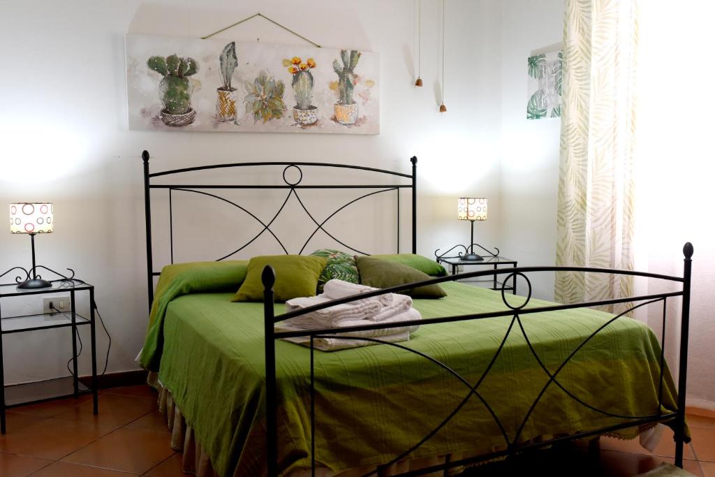 a bedroom with a green bed with two night stands at Hotel California in Carloforte