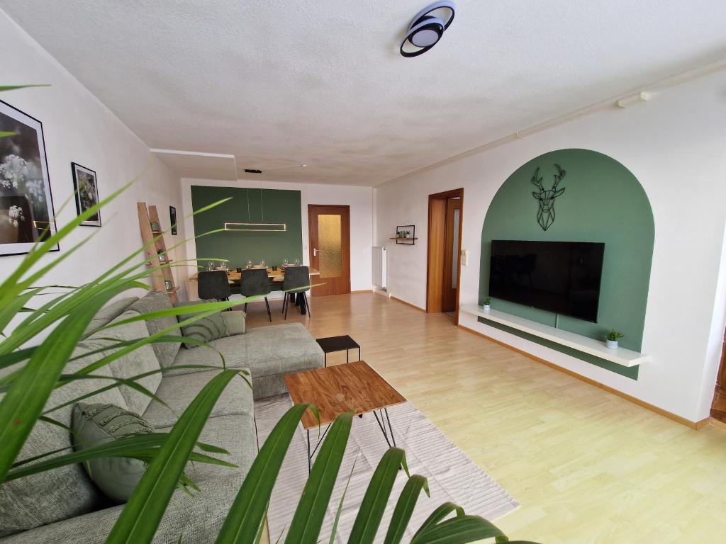 a living room with a couch and a flat screen tv at Große Terrasse, Netflix, 5min zum Skilift, 6 Personen, Waldnah, in Schonach