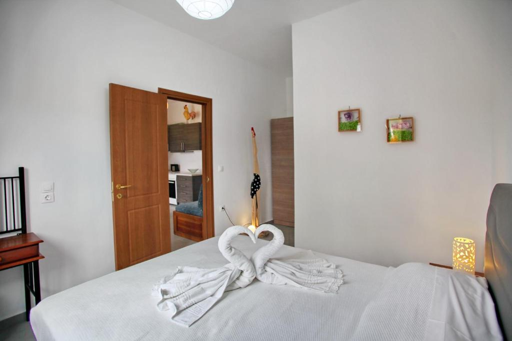 a white bed with a white towel on it at Finikas Apartments in Skopelos Town