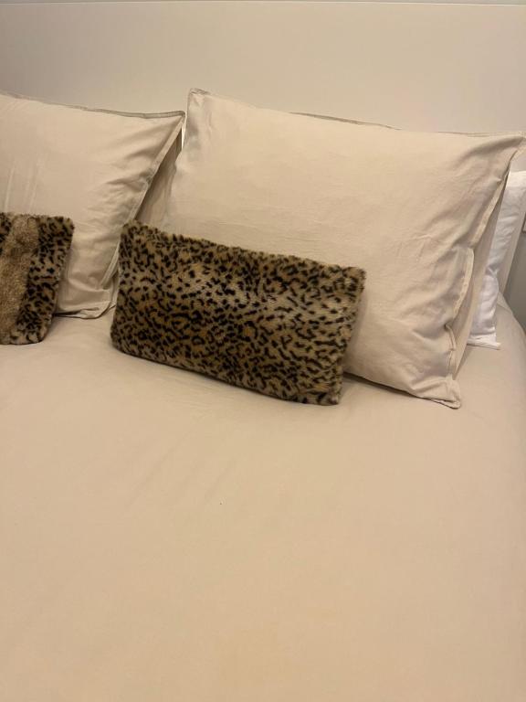 - un lit avec deux oreillers et un oreiller à motifs léopards dans l'établissement Casa con piscina, à Cedeira