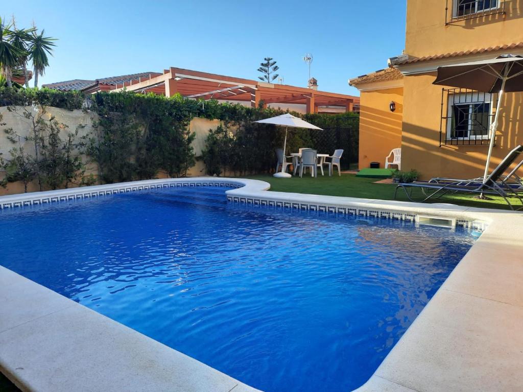 a swimming pool in front of a house at Matalascañas in Matalascañas
