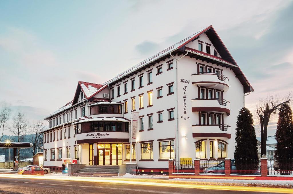 a large white building on the corner of a street at Hotel Simeria in Gura Humorului