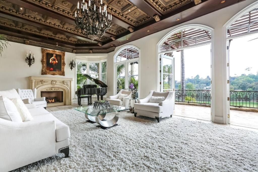 a living room with white furniture and a piano at Bel Air Luxury Villa in Los Angeles