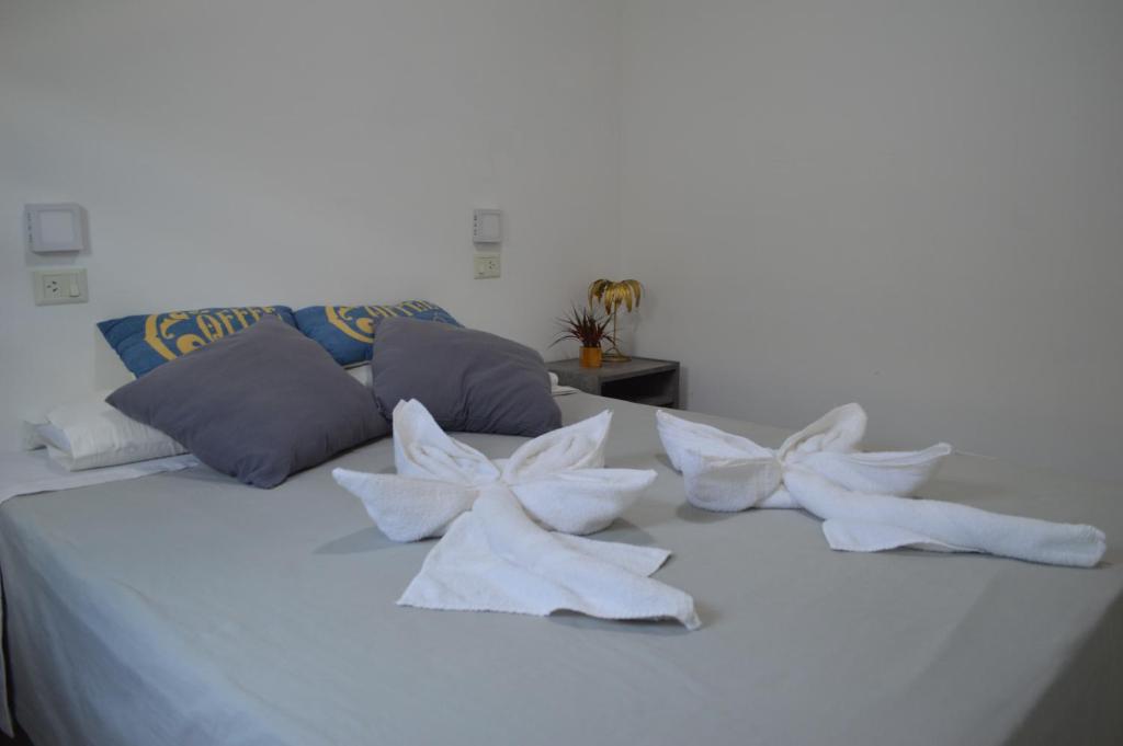 Una cama blanca con almohadas blancas. en Apart Hotel Verona en Puerto Madryn