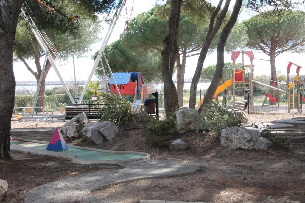 park z placem zabaw z huśtawką w obiekcie mobil home au lac des rêves w mieście Lattes